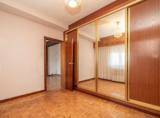 Armario empotrado antiguo con puertas de espejo y marco dorado sobre parquet de mosaico, antes de la reforma