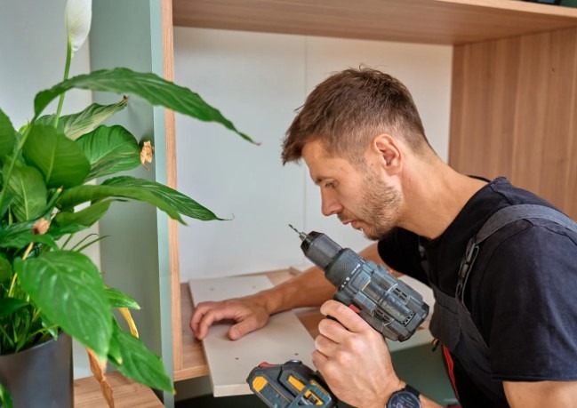 Montador profesional ensamblando mueble con taladro