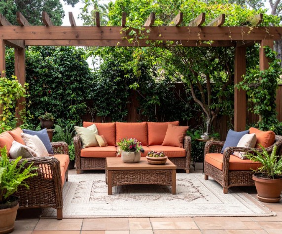 Pérgolas de madera a medida en Málaga Pérgola de madera rústica sobre un patio mediterráneo con muebles de exterior