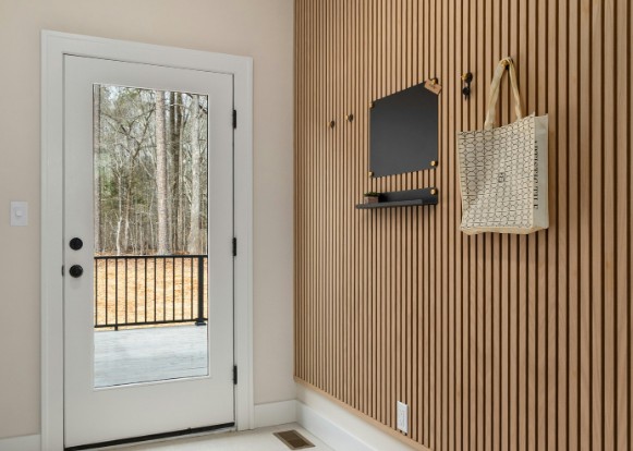 Recibidor con panel de lamas de madera, repisa y perchero integrados en el propio panel