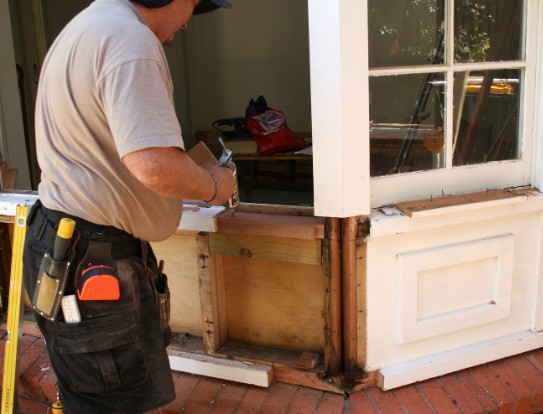 Reparación de ventanas de madera en Málaga Carpintero reparando el durmiente inferior de una ventana de madera con carcoma en Málaga
